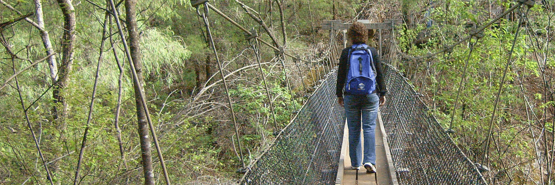 walking across swingbridge with waterproof himal backpack